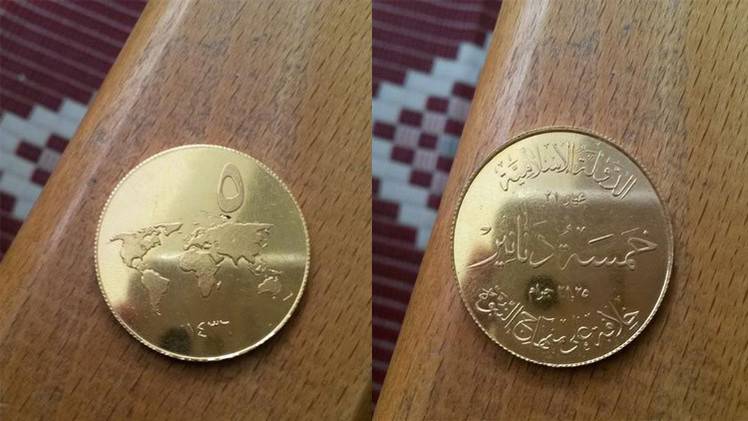 بالصور - تنظيم "داعش" يسك عملته الذهبية مع خريطة العالم على الوجه