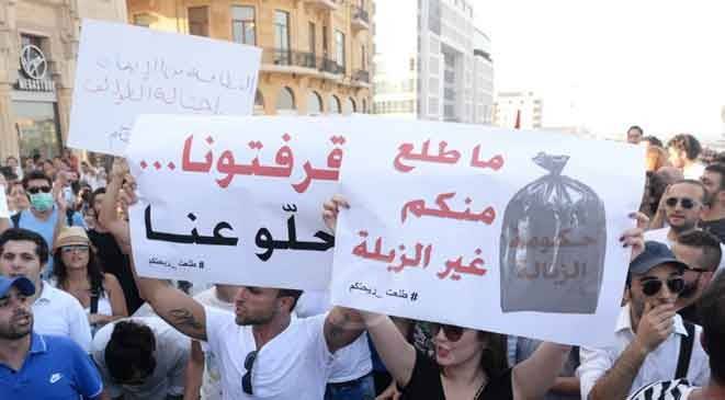 متطوعو حملة "طلعت ريحتكم" يقومون برمي النفايات أمام الوزارات