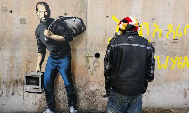 رسم على جدار في مخيم للاجئين يذكر أوروبا بأصل ستيف جوبز