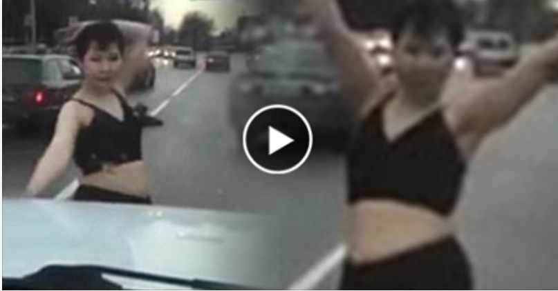 بالفيديو: شاهد امرأة تنتابها حالة جنونية وتخلع ملابسها وترقص أمام السيارات!