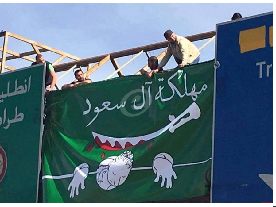 بالصور:  رفع علم كاريكاتوري للسعودية على جسر المشاة بالزلقا- جل الديب والقوى الامنية تزيله