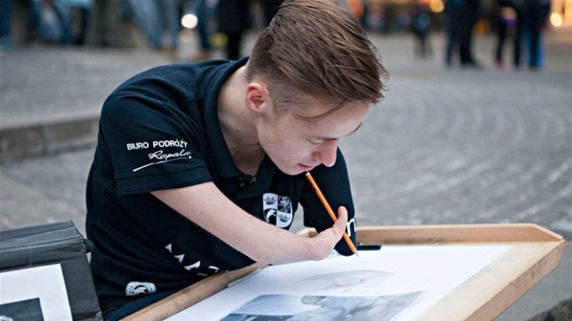 شاب مبدع من دون يدين يرسم لوحات مذهلة
