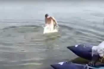 بالفيديو غطس بالمياه وخرج مع سمكة معلقة بعضوه التناسلي