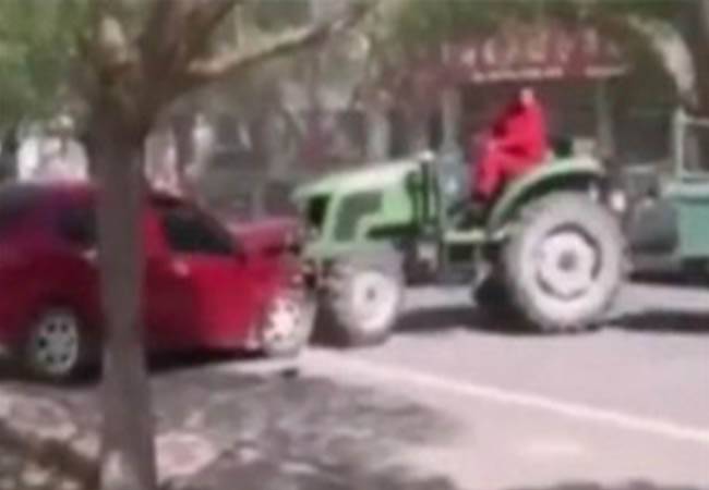 بالفيديو.. مزارع غاضب يحطم بجرّاره سيارة سدت طريقه