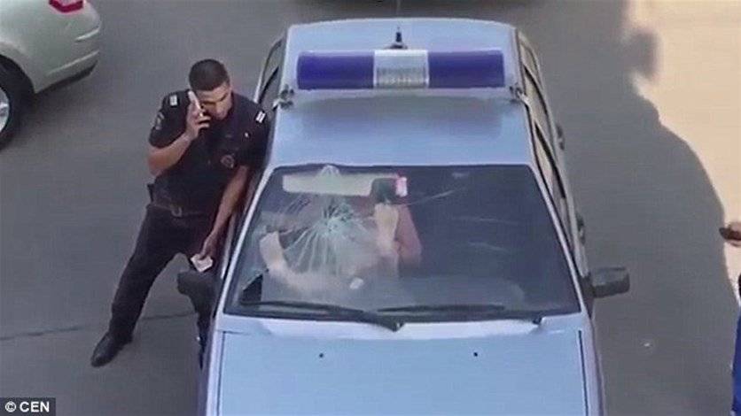 بالفيديو: سيدة غاضبة بالبيكيني تحطّم زجاج سيارة الشرطة!