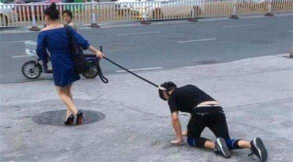 بالصور.. امرأة تجر رجلاً مثل الكلب خلفها في الشارع