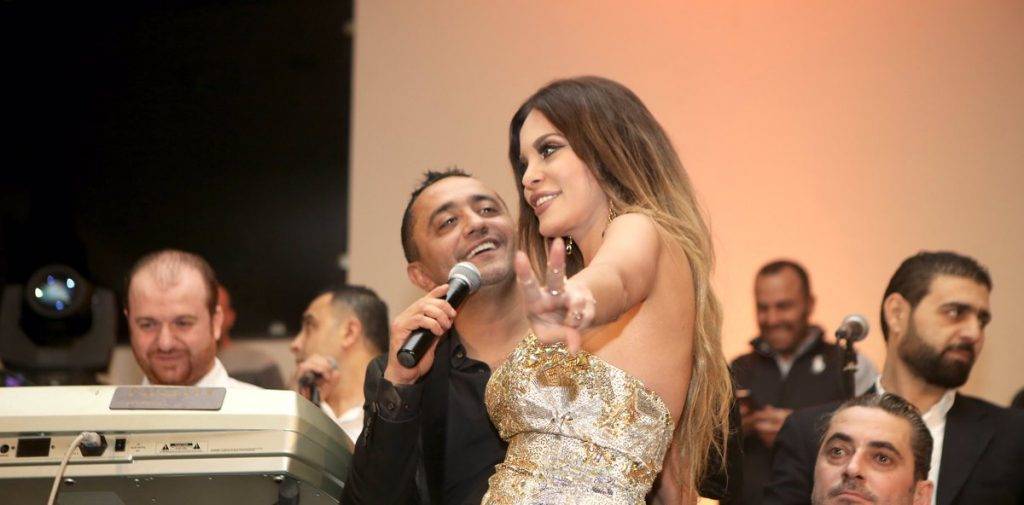 بالصور دومينيك حوراني تخلع حذائها في حفلة رأس السنة مع على الديك وتسأل: “مش عارفة ليش قلعني جزمتي علوش ؟”
