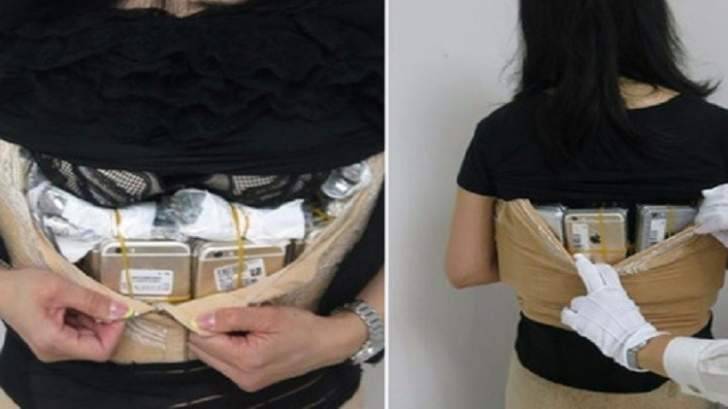 صينية تحاول تهريب 100 آيفون تحت ملابسها