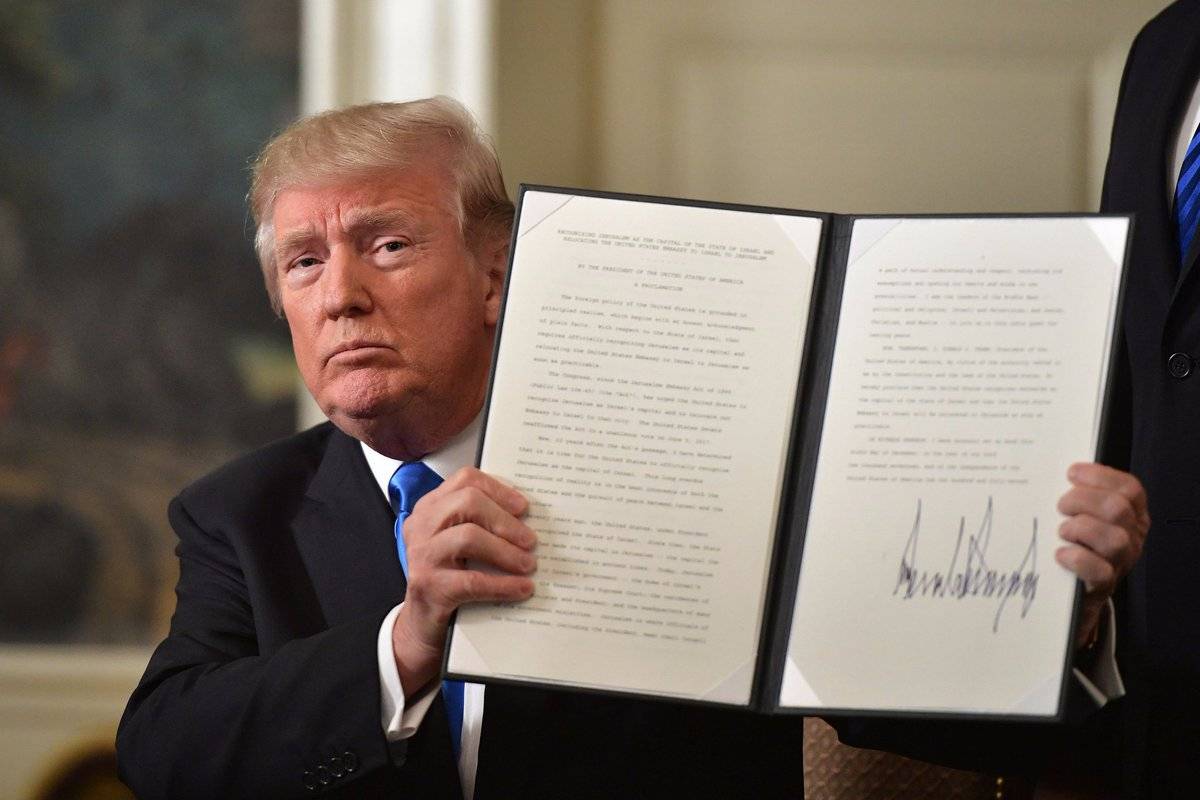 ترامب ممسكا بقرار نقل السفارة الاميركية الى القدس بعد توقيعه منذ لحظات (أ ف ب)