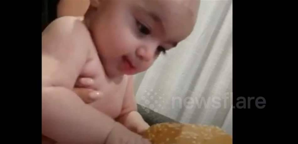 مشهدٌ طريف.. رضيعة جائعة تحاول تناول الـ"بيغ ماك"! (فيديو)