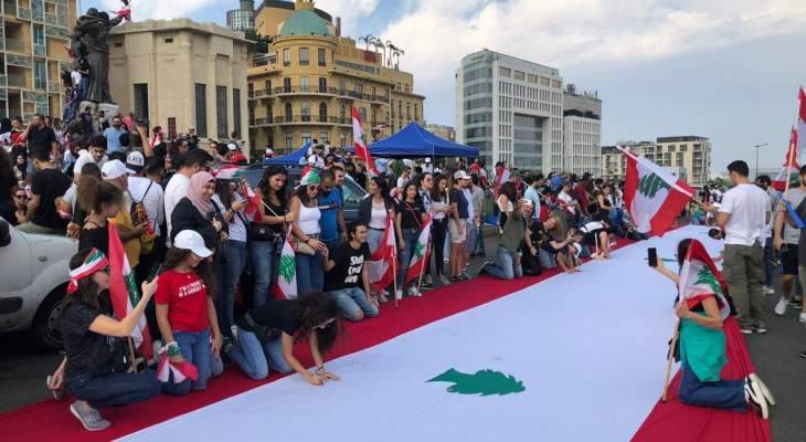 طلاب "الكتائب" جالوا بعلم لبناني عملاق في ساحة الشهداء مطلقين حملة توقيع لاستقالة الحكومة