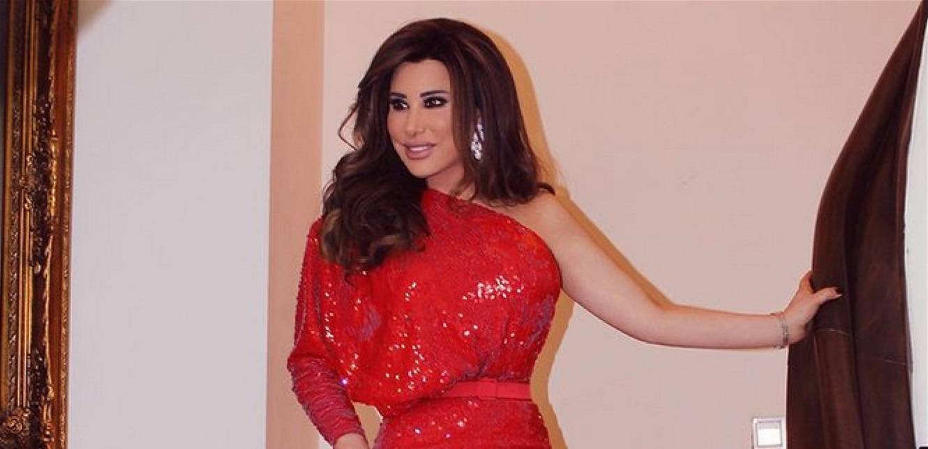 خطفت الأنظار بإطلالتها.. إليكِ كلفة فستان نجوى كرم الأحمر في يوم زفاف ابن شقيقها