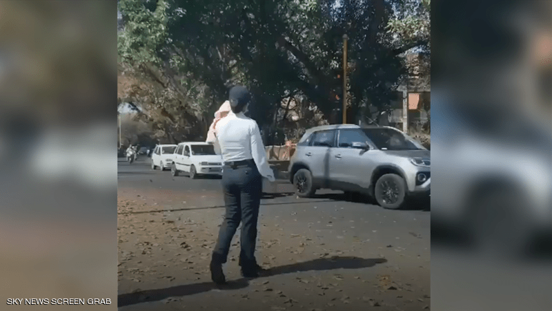 شرطية تنظم المرور وهي تحمل رضيعها
