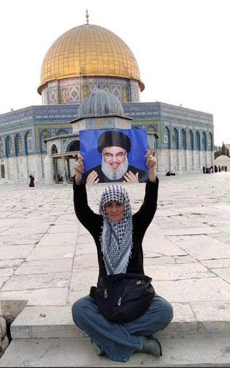 فلسطينية تحمل صورة امين عام حزب الله السيد حسن نصرالله من امام المسجد الاقصى