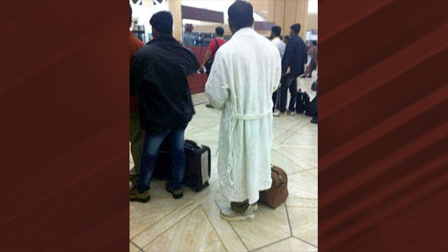 مسافر في مطار الرياض في روب الحمام
