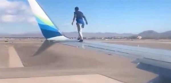 واقعة "غريبة" في مطار.. رجل يسير فوق جناح طائرة (فيديو)